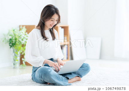 リビングでパソコンを操作する若い女性 リビングでパソコンを操作する若い女性 106749878