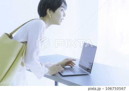ノートパソコンを操作する若い女性のファッションポートレート ハイキー ノートパソコンを操作する若い女性のファッションポートレート ハイキー 106750567