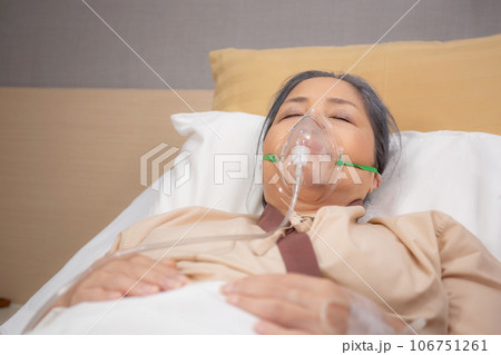 Patient elderly asleep with disease or unconscious in oxygen mask on bed at hospital ward. Patient elderly asleep with disease or unconscious in oxygen mask on bed at hospital ward. 106751261