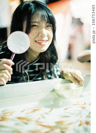 縁日で金魚すくいで遊ぶ女の子 106753485