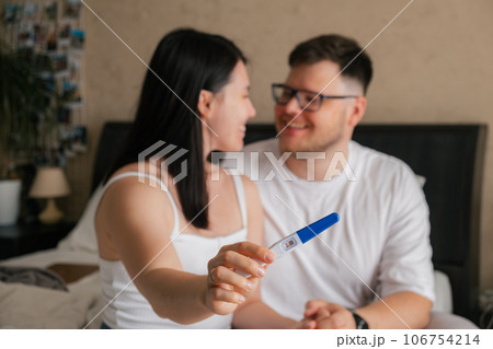 happy couple looking at positive pregnancy test 106754214