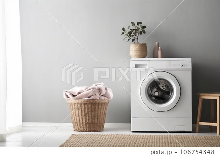 Modern washing machine and laundry basket near white wall indoors, space for text. Bathroom interior 106754348