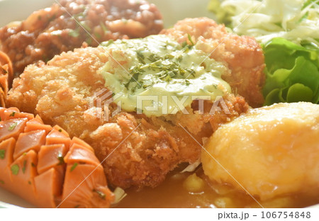 crispy fried chicken meat stuffed cheese with mash potato dressing gravy sauce and spaghetti and cabbage cos lettuce salad couple sausage on plate  106754848