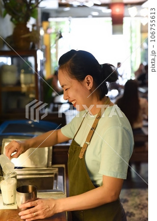 Vietnamese barista using a mixer for condensed milk in glass cup for preparing vietnamese coffee Cafe Sua 106755613