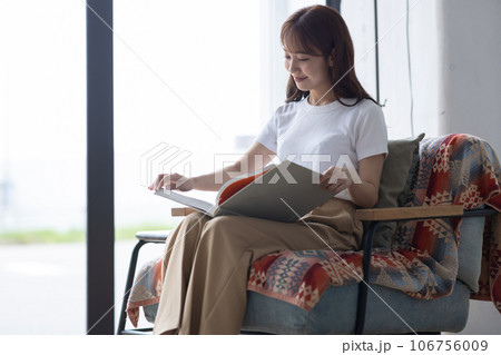 ソファで本を読む可愛い女性 106756009