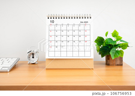 The October 2023, Monthly desk calendar for 2023 year on wooden table with alarm clock. 106756953