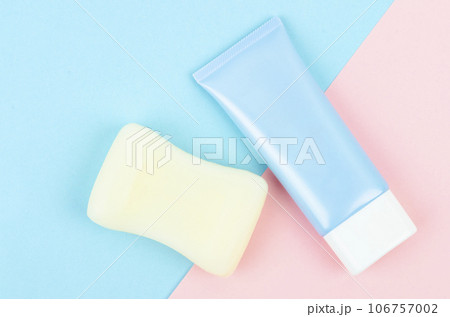 Top view of blue squeeze bottle plastic tube and herb soap bar on beautiful background for branding of medicine or cosmetics. 106757002