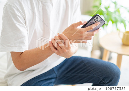 手首が痛いスマホを持つ男性 106757585