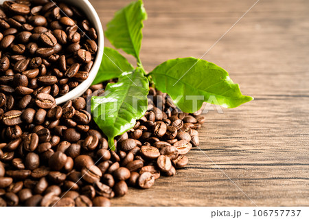 Coffee brown bean medium roasted with fresh green leaf. Coffee brown bean medium roasted with fresh green leaf. 106757737