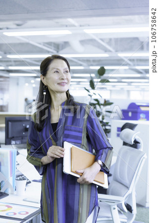 オフィスに立つシニアビジネスウーマンのポートレート　縦位置 106758642