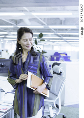 オフィスに立つシニアビジネスウーマンのポートレート　縦位置 106758647