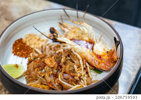 Pad Thai with river prawn serve on plate. It is a stir-fried rice noodle thai dish Pad Thai with river prawn serve on plate. It is a stir-fried rice noodle thai dish 106759593