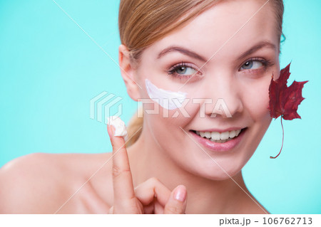 Skin care. Face of young woman girl with red maple leaf. 106762713