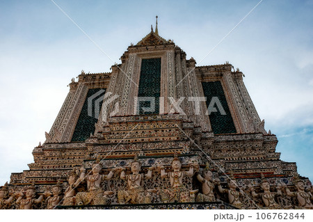 A temple in Thailand with intricate details and a tall spire. The temple has a tall spire with a golden tip and is decorated with intricate details and patterns. 106762844