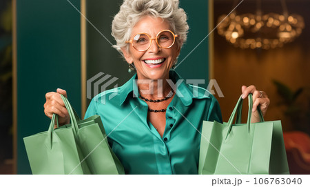 Happy elegant older woman holding green shopping bags. Concept of shopping, sales season, Green Monday, Black Friday 106763040