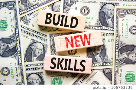 Build new skills symbol. Concept word Build new skills on beautiful wooden block. Dollar bills. Beautiful dollar bills background. Business, education build new skills concept. Copy space. Build new skills symbol. Concept word Build new skills on beautiful wooden block. Dollar bills. Beautiful dollar bills background. Business, education build new skills concept. Copy space. 106763239