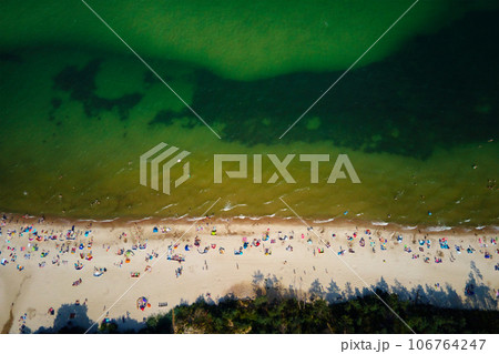 Aerial view of sea landscape with crowded sand beach in Wladyslawowo. Baltic sea coastline with swimming people in Poland. Resort town in summer season 106764247