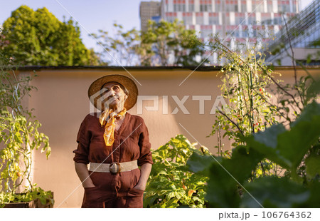 Portrait of confident senior woman standing in urban garden. Portrait of confident senior woman standing in urban garden. 106764362