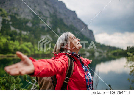 Waist up shot of happy elderly woman with hands in the air. Waist up shot of happy elderly woman with hands in the air. 106764411