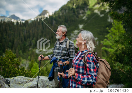 Potrait of active senior woman hiking with husband in autumn mountains. 106764430