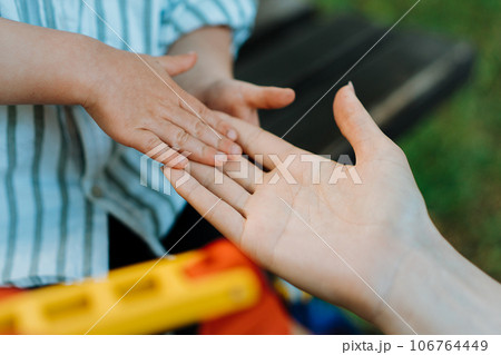 Mother and child are touching palms, expressing love. Mother and child are touching palms, expressing love. 106764449