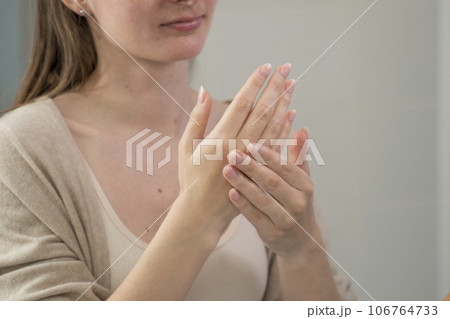 Close-up of women's hands applying hand moisturizer Close-up of women's hands applying hand moisturizer 106764733