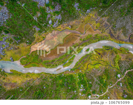 Aerial View of River in Vibrant Green Meadows in the Canadian Mountain Landscape. 106765099