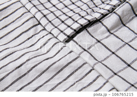 Plaid material. Towel on the table. Wrinkled fabric with stripes. Plaid material. Towel on the table. Wrinkled fabric with stripes. 106765215