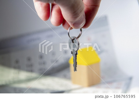 Keys in hand and house. Handing over the keys to the apartment. Keys in hand and house. Handing over the keys to the apartment. 106765595