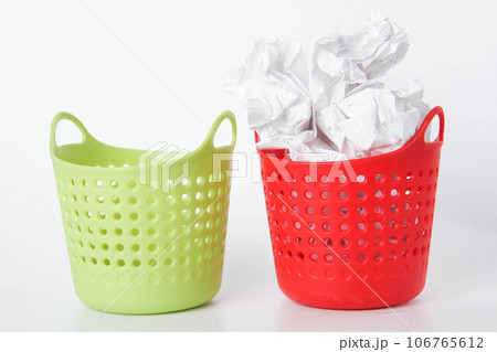 Two baskets. The green basket is empty - the red one is full. Crumpled paper in the trash can. Two baskets. The green basket is empty - the red one is full. Crumpled paper in the trash can. 106765612