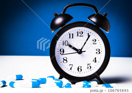 Time to take your medicine. Pill reminder. Tablets and alarm clock. 106765693