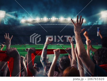 Football scene at night match with with cheering fans at the stadium 106765920