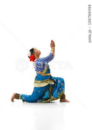 Elegant, artistic indian woman in traditional dress dancing against white studio background 106766498
