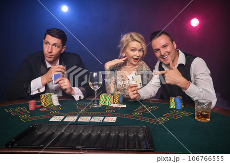 Group of a young wealthy friends are playing poker at a casino. Group of a young wealthy friends are playing poker at a casino. 106766555