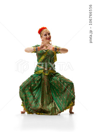 Indian dance pose. Beautiful woman in traditional indian dress dancing against white studio background Indian dance pose. Beautiful woman in traditional indian dress dancing against white studio background 106766556