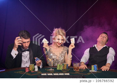 Group of a young wealthy friends are playing poker at a casino. Group of a young wealthy friends are playing poker at a casino. 106766592