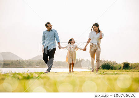 Happy family taking a walk together in the countryside on a beautiful sunny day, feeling healthy and active in the outdoors, Happy family day Happy family taking a walk together in the countryside on a beautiful sunny day, feeling healthy and active in the outdoors, Happy family day 106766626