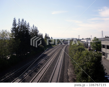 four lane train track with distant train rolling though four lane train track with distant train rolling though 106767135