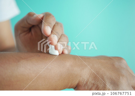 man applying beauty cream onto skin  106767751