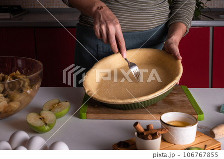 Authentic female hands making a base for a shortcrust pie, pie crust recipe Authentic female hands making a base for a shortcrust pie, pie crust recipe 106767855
