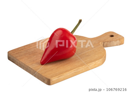 A pod of hot red pepper on a cutting board over a white background. 106769216