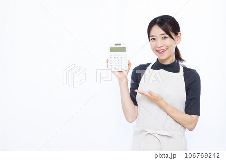 白い背景の前で電卓を持つ30代の主婦 白い背景の前で電卓を持つ30代の主婦 106769242