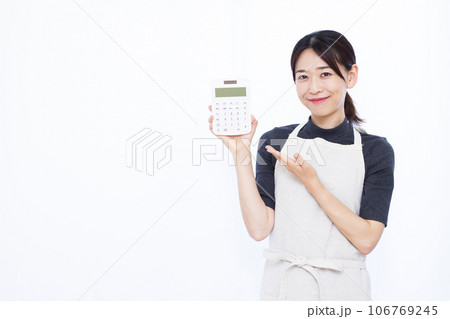 白い背景の前で電卓を持つ30代の主婦 白い背景の前で電卓を持つ30代の主婦 106769245