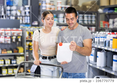 Husband and wife choose plastic canister together in hardware department of hardware store 106770779
