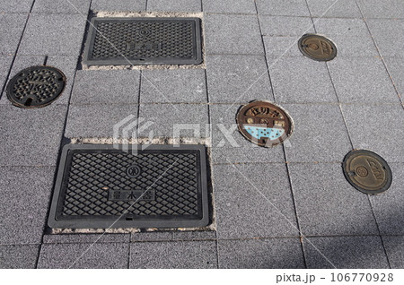 歩道に並ぶ量水器と仕切弁と水バルブとガスのマンホール 歩道に並ぶ量水器と仕切弁と水バルブとガスのマンホール 106770928