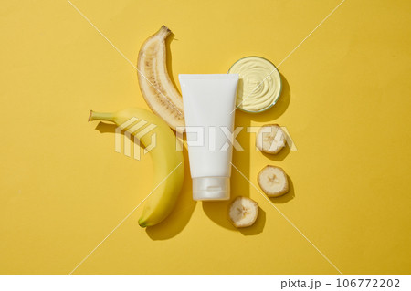 Flat lay of a glass petri dish filled with cream texture, banana slices and an unlabeled tube. Banana (Musaceae) contains vitamins A and C. Branding skin care mockup Flat lay of a glass petri dish filled with cream texture, banana slices and an unlabeled tube. Banana (Musaceae) contains vitamins A and C. Branding skin care mockup 106772202