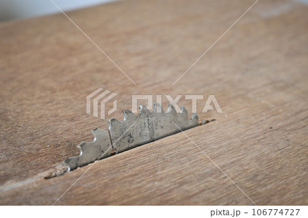 sharp metal saw on wood plank texture background, construction machine 106774727