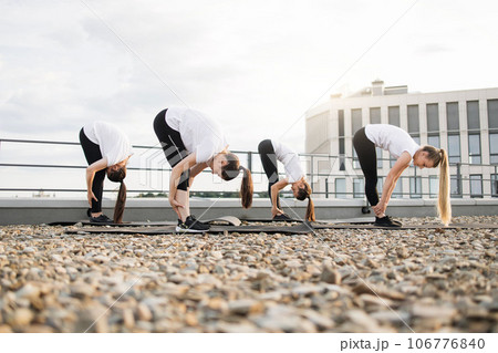 Ladies in activewear bending forward during outdoor exercise 106776840