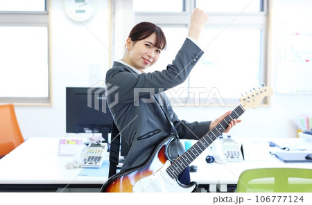職場でエレキギターを演奏する女性会社員イメージ 職場でエレキギターを演奏する女性会社員イメージ 106777124