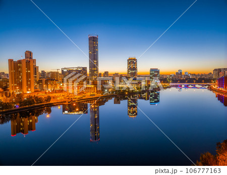 Yekaterinburg city and pond aerial panoramic view at summer or early autumn night. Night city in the early autumn or summer. Yekaterinburg city and pond aerial panoramic view at summer or early autumn night. Night city in the early autumn or summer. 106777163